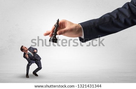 Big hand holding chessman and down little afraid businessman concept in a light space Royalty-Free Stock Photo #1321431344