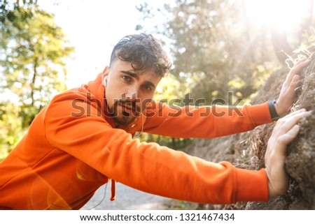 Picture of handsome young sports fitness man runner outdoors in park.