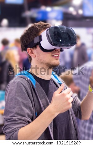 Young man is using virtual reality glasses on an expo