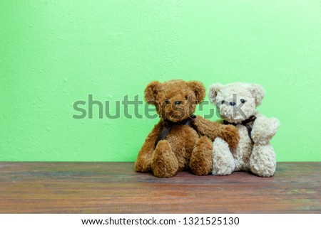 Teddy bear on old wood ,green wall background.