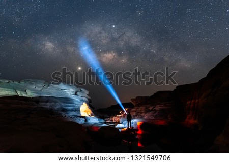 Travelers using flashlight to searching Milky way galaxy in the dark night in the stone forest, rock forest. night landscape astronomy photography captured in February 2019.