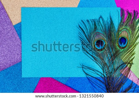 Carnival shiny background with colorful peacock feathers on sparkling glitter paper, copy space, text place