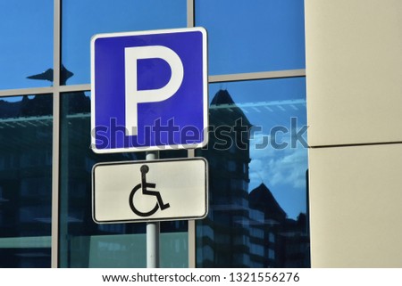 Road sign Parking only for handicapped people on the background of a modern shopping center building