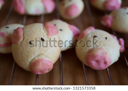 blur homemade pink cartoon pig cookies on stainless steel rack at table