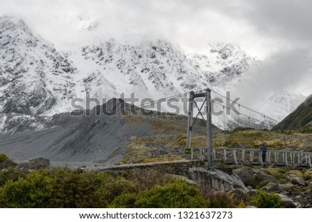 Snowy mountains and hanging bridge at Hooker Valley Track