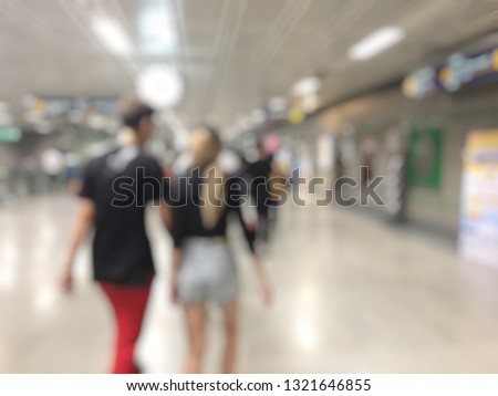 Blurred image of City commuters in subway. Unrecognizable humans moving through a subway tunnel. Blurred background.