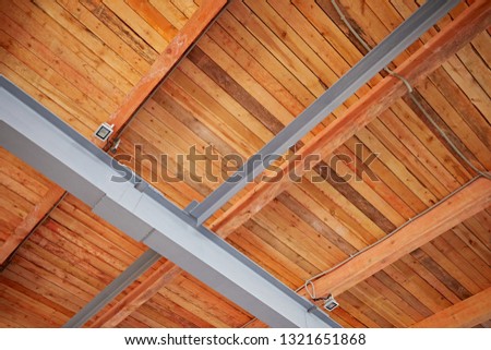 Metal beams of a wooden roof. View from inside the room. Architectural and building structures