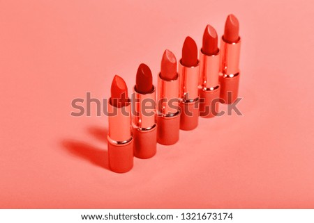 Makeup lipsticks on living coral color background. Minimalism concept