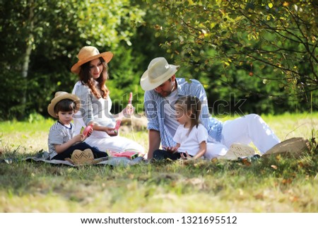 Family with children eating watermelon on the nature in campaign.