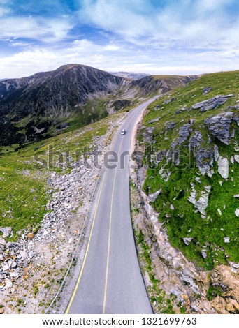 Aerial view on transalpina, cars on road on Romania mountain, travel, adventure concept, motorcyclists way, vacation place, mountains top, summer day, vertical photo