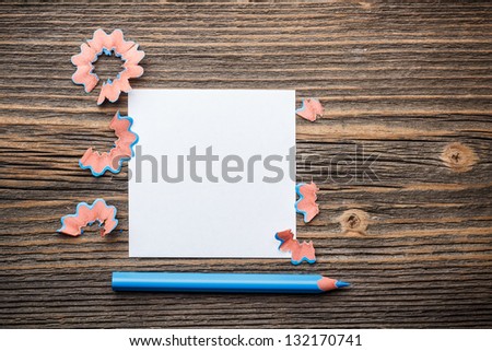 Pencil, paper and shavings on rustic wooden background