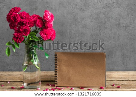 wedding craft paper card with bouquet of red rose flowers in vase. mock up. holiday or wedding background. still life