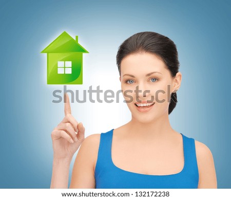 picture of beautiful woman pointing her finger on green house