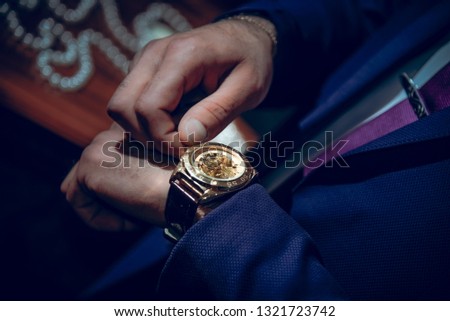 man adjusts his watch
Man in black suit wear new watches. Luxury style Hand of a man in a black suit with a watch Man in a suit adjusts his black watch on the wirst - Image
