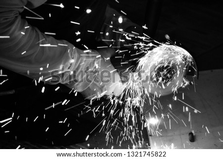 Do-it-yourself work in the workshop. Bulgarian. Sparks. Metal processing. Black and white photo.
