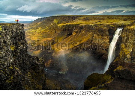 A man Standing on a Dramatic landscape of Haifoss Waterfall in Landmannalaugar canyon, Iceland Royalty-Free Stock Photo #1321776455