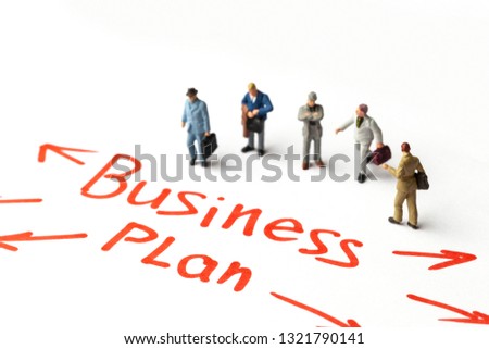 Miniature people on paper with arrows and Business Plan text