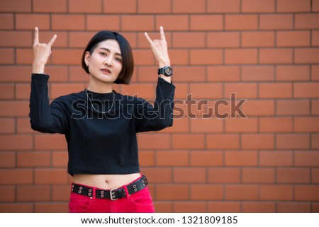 Portrait of beautiful asian chic girl pose for take a picture on wall background,Lifestyle of teen thailand people,Modern woman happy concept,Punk rock style