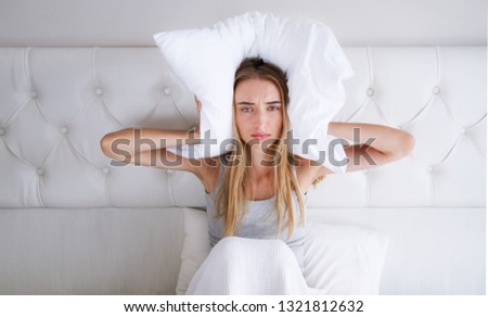 Young White Woman With Insomnia Covering Head And Ears With Pillow : Bad Sleep Problem Concept Royalty-Free Stock Photo #1321812632