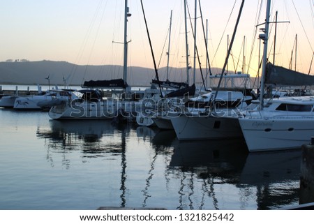 Boats on calm water with sunset background