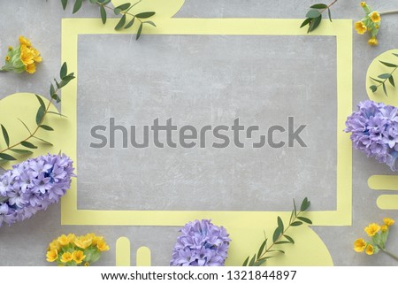 Yellow paper frame with copy-space decorated with blue hyacinth flowers and eucalyptus leaves