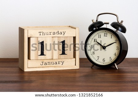 Wood calendar with date and old clock. 11 January