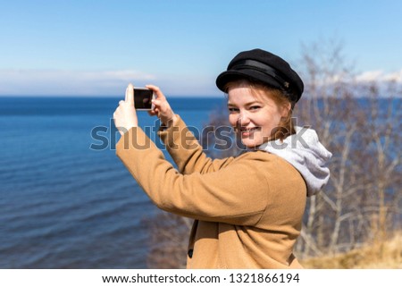 Cute girl takes pictures on a smartphone sights in solo travel. Share your impressions!