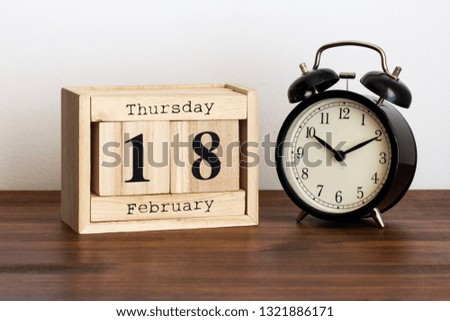 Wood calendar with date and old clock. 18 February