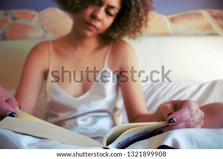 Relaxed Afro Girl reading a book on bed 