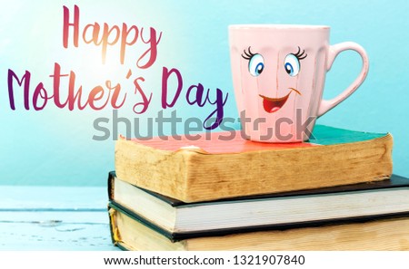 cup coffee with smiling face of woman above books, happy mother's day concept