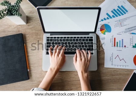Female hands working on modern laptop. Office desktop on wooden background