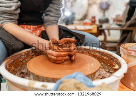 Craftsman hands making pottery bowl. Woman working on potter wheel . Family business shop sculpts pot from clay view top.