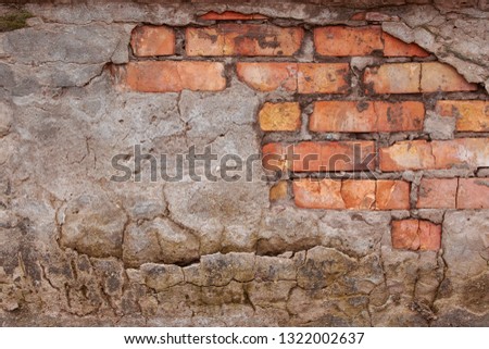 The wall is of red brick with natural defects: faults, cracks, chips, scratches, crevasses, roughness. Horizontal masonry. Part of the old wall. Could be used as background for design.