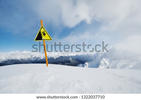 Sign "Caution abyss" at a ski resort in winter