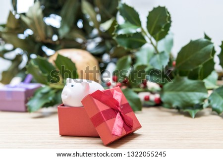 Fall and winter seasonal background, copy space image with laurel leaves and a piggy bank