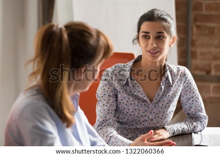 Indian businesswoman speaking to colleague or hr during job interview, young professional hindu woman manager consulting client or explaining giving advice teaching at business office meeting Royalty-Free Stock Photo #1322060366