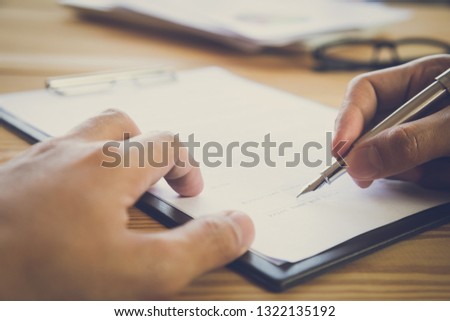 Business man signing a contract. Owns the business sign personally, director of the company, solicitor. Real estate agent holding house, financial or renting property, merger and acquisition concept.