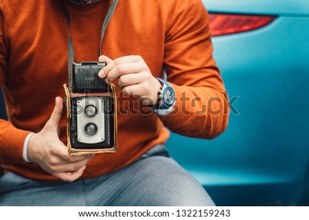 Photographer man taking photo with vintage old camera