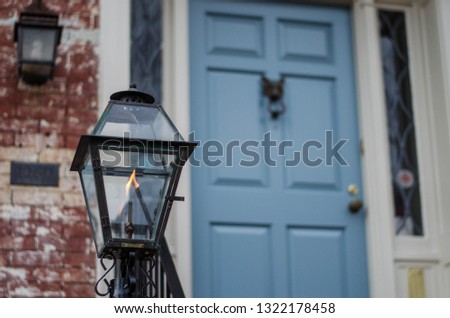 gas lamp near the entrance to the old house with a blue door. Georgetown Washington DC, USA