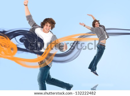 Two of the same young man jumping for joy with orange and navy smoke trails on blue background