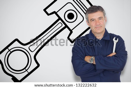 Mature mechanic standing next to car symbol while looking at camera