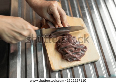 Chef cutting meat.
