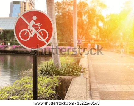 Red sign no bicycle in public park with sunlight. Free space for any text design.
