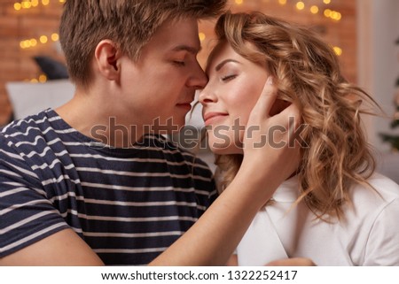Close up portrait of a beautiful couple sitting on the floor embracing and looking to each other