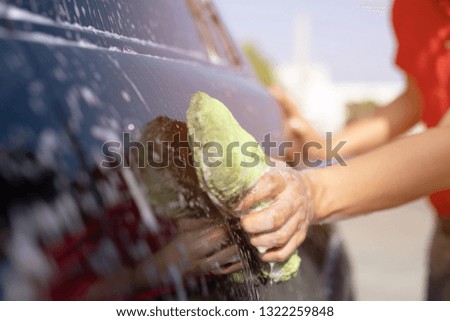 people man Cleaners holding hand green sponge for washing car. Concept car wash clean.