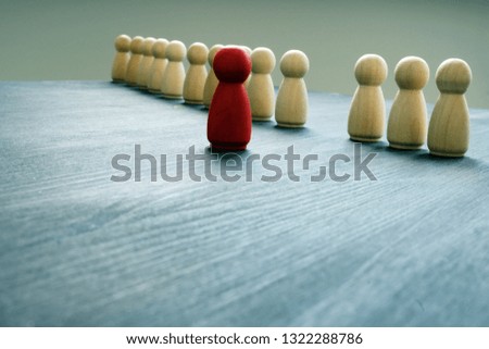Stand out from the crowd concept. Red figurine as symbol of uniqueness.