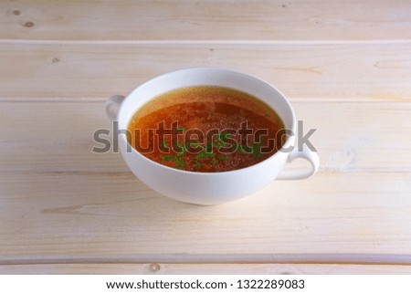 Rich beef broth on wooden table