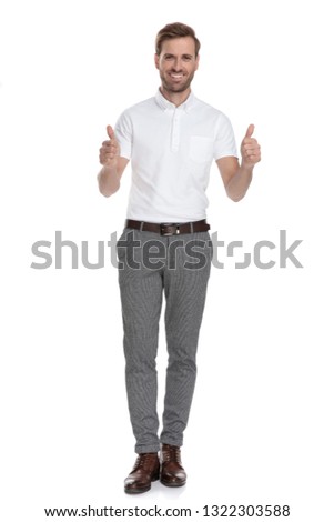 successful young smart casual man makes the ok thumbs up hand sign while standing on white background