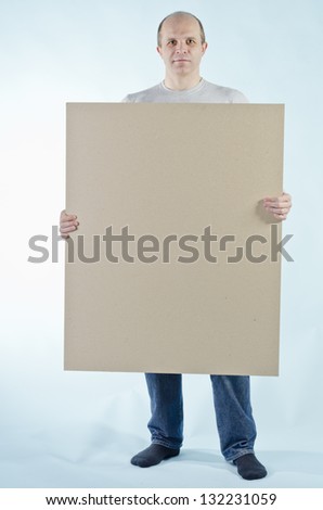 portrait of man holding empty table to put words on blue background
