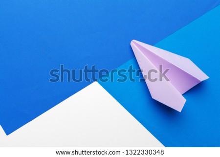 Flat lay of white paper plane and blank paper on pastel blue color background